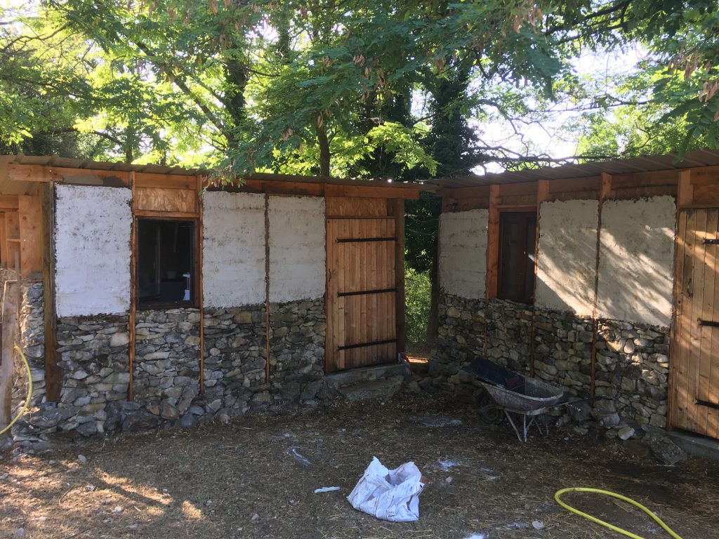 Abri en bois et en pierre du refuge Altervita, ouvert sur la cour